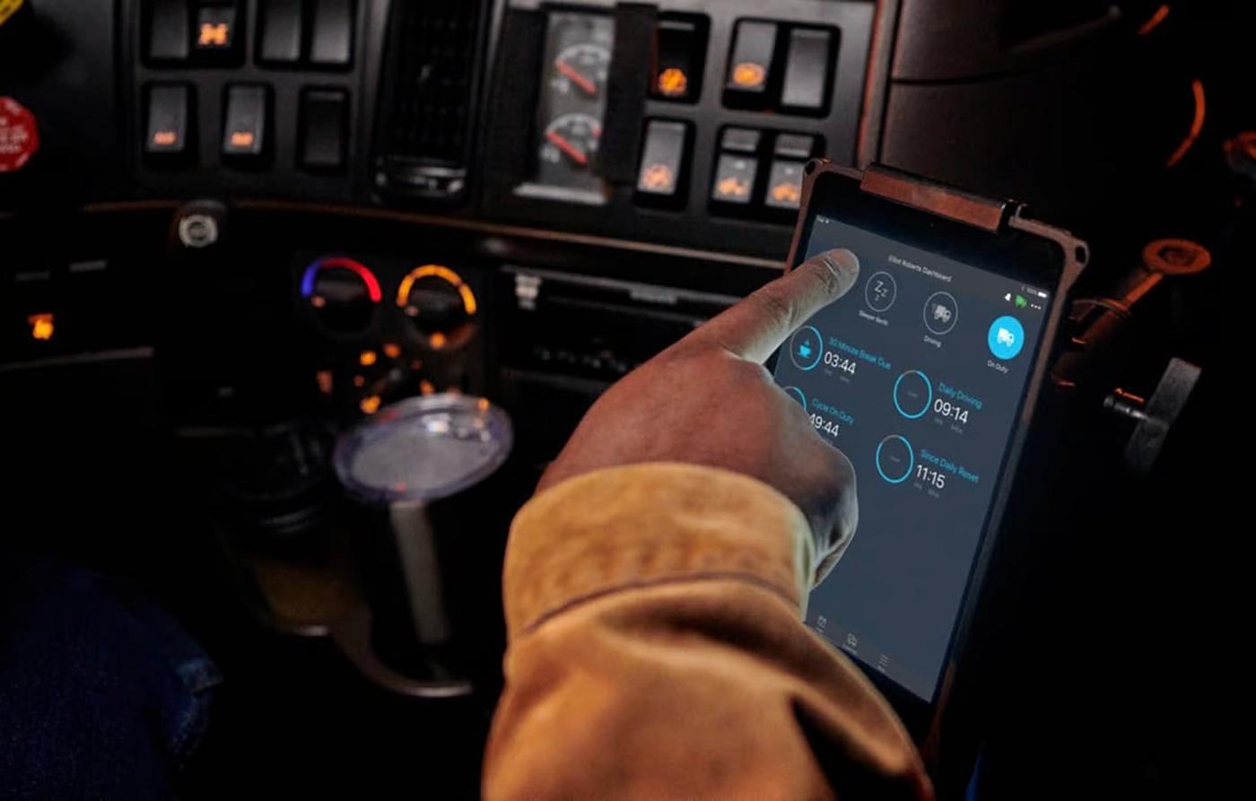 Logbook ELD app on a driver's phone screen in a truck